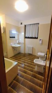 a bathroom with a tub and a toilet and a sink at Casa Vacanza Biasi in Pergine Valsugana
