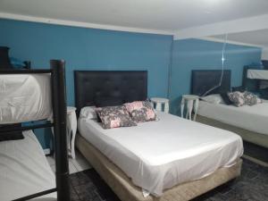 two beds in a room with blue walls at la reyna in Monte Grande