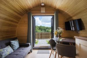 Una sala de estar con un sofá y una mesa y una ventana. en Polgooth Inn, en St Austell