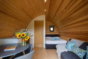 Una sala de estar con una mesa y una cama. en Polgooth Inn, en St Austell