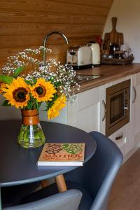 a vase of sunflowers on a table in a kitchen at Polgooth Inn in St Austell