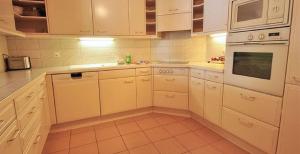 a kitchen with white cabinets and white appliances at Gorgeous Home Saser in Santa Cristina in Val Gardena