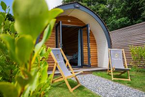 two chairs sitting in front of a shed at Polgooth Inn in St Austell