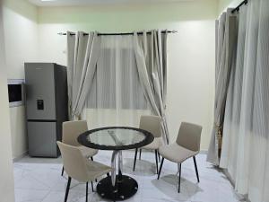 a dining room with a glass table and chairs at Lakeside Hilltop Haven -3 Bedroom House in Katamanso