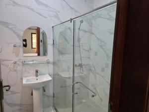 a bathroom with a sink and a glass shower at Lakeside Hilltop Haven -3 Bedroom House in Katamanso +6 photos