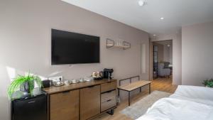 a bedroom with a flat screen tv on the wall at Hotel Varmaland in Varmaland