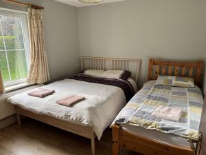 Dos camas individuales en una habitación con ventana. en Brú na Dromoda/Dromid Hostel, en Killeenleagh Bridge 51 fotos más
