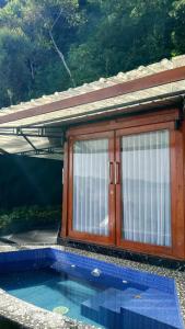 a small house with a window next to a swimming pool at Adelisca Glamping, Villa and Cafe in Kubupenlokan