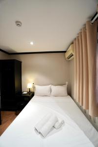 a bedroom with a white bed with a towel on it at HY Local Budget Hotel - 5 mins walk to Hoi An Ancient Town in Hoi An