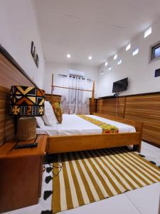 a bedroom with a large bed and a television at Résidence Tourine cosy en plein centre ville d'Akwa in Douala