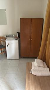 eine Küche mit einem Kühlschrank und einem Tisch mit Handtüchern in der Unterkunft ΠΑΝΣΙΟΝ Μελίκη 