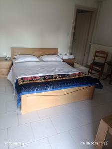 ein Schlafzimmer mit einem großen Bett mit Holzrahmen in der Unterkunft ΠΑΝΣΙΟΝ Μελίκη 