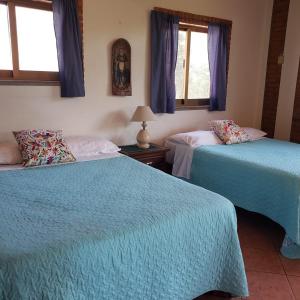 1 Schlafzimmer mit 2 Betten mit blauer Bettwäsche und Fenstern in der Unterkunft Casitas Las Palmas - La Brisa in Punta Mita