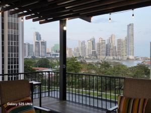 a balcony with two chairs and a view of a city at Esplendido Apartamento in Panama City