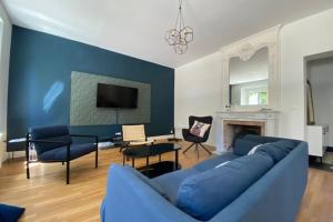 a living room with a blue couch and a fireplace at Stunning 230m with garden in the city center in Caen +18 photos