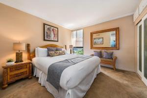 a bedroom with a large bed and a mirror at Maui Kai 808 · MK 808 OceanFront 1BD Kaanapali Beach Ocean Views in Lahaina +43 photos