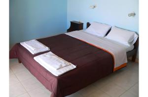 a large bed with two towels on top of it at Apraos Bay Hotel in Apraos