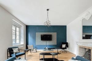 a living room with a blue accent wall at Stunning 230m with garden in the city center in Caen