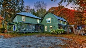 uma casa verde no meio de um quintal em Family Winter Home in the Eastern Townships em Ayers Cliff