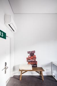 Una pila de libros sobre un banco en una habitación en Moon Hill By Joivy, en Sintra