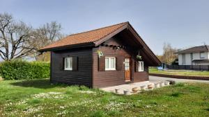 a small house in a grassy yard with at Petit chalet proche Lac Léman in Sciez +8 photos