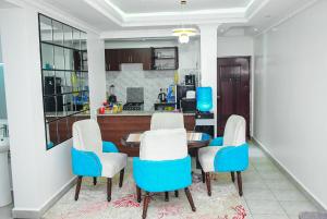a kitchen with blue and white chairs and a table at Polo Executive Abodes in Nairobi