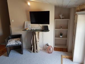 a living room with a flat screen tv on a wall at Calmacé in Gignac