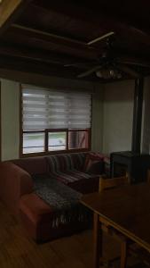 a living room with a couch and a window at La cascada in Futaleufú
