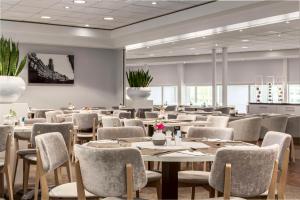 a restaurant with tables and chairs in a room at NH Utrecht in Utrecht