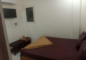 a small bedroom with a bed and a table at Hotel Kalaptaru in Nainital