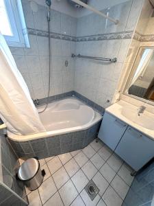 un bagno con vasca e lavandino di 布达佩斯市中心西火车站公寓 a Budapest