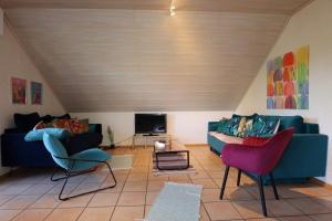 a living room with a blue couch and two chairs at Ferienwohnung Freizeitglück nahe Europapark - Mein Schwarzwaldhäusle in Kappel-Grafenhausen