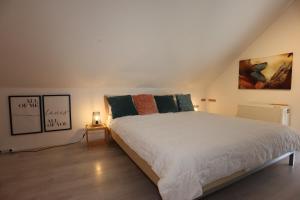 a bedroom with a large white bed in a attic at Ferienwohnung Freizeitglück nahe Europapark - Mein Schwarzwaldhäusle in Kappel-Grafenhausen +46 photos