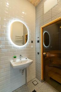 een badkamer met een wastafel en een spiegel bij Apartments24 Black 1903 in Rakvere +26 foto's