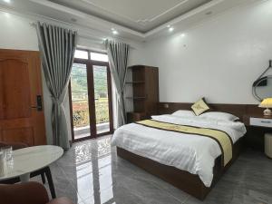 a bedroom with a large bed and a table at Oanh Thư Hotel in Mèo Vạc +41 photos