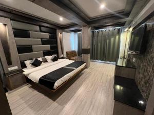 a bedroom with a large bed and a television at Victory Hotel and Restaurant by GS Hospitality in Shimla +54 photos