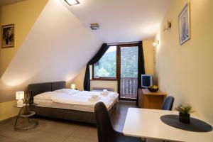 a small room with a bed and a table at Apartmánový dom Fatrapark 1 s Wellness - Hlavná recepcia in Ružomberok +70 photos