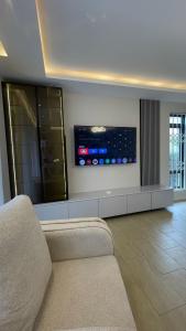 a living room with a couch and a flat screen tv at Eric Wilkins villas in Kampala