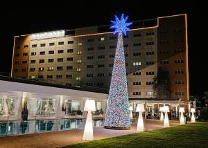 een grote kerstboom voor een gebouw bij The Sydney Hotel in Bologna