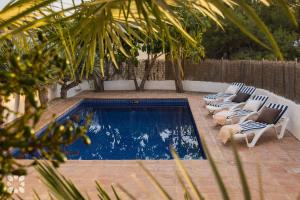 una piscina con tumbonas y una piscina en Villa Las Salinas by Abahana Villas, en Rada de Moraira