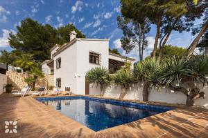 una villa con piscina frente a una casa en Villa Las Salinas by Abahana Villas, en Rada de Moraira