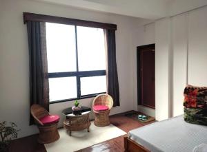 Un dormitorio con una cama y dos sillas y una ventana. en Degants pad, en Darjeeling 6 fotos más