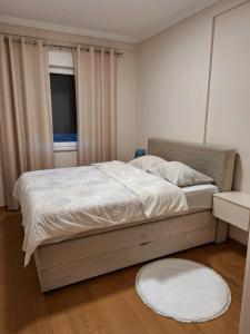 a bedroom with a large bed with a window at Apartman REINA in Prijedor
