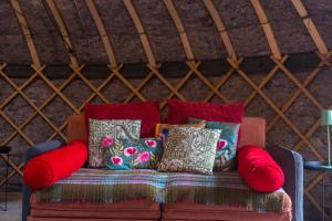 eine Couch mit Kissen darauf in einer Jurte in der Unterkunft Giant Yurt Sleeping 8 with Spa, Catering, Walled Gardens, Nature Reserve, Free Parking in Scunthorpe