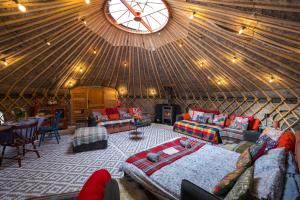 ein großer Raum mit einer Jurte, die mit einem Bett und Sofas ausgestattet ist in der Unterkunft Giant Yurt Sleeping 8 with Spa, Catering, Walled Gardens, Nature Reserve, Free Parking in Scunthorpe