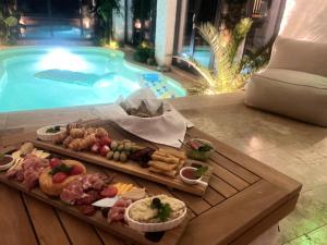 a tray of food on a table next to a pool at Villa Westfalia Boutique Villa & SPA Adult Only` in Târgu Secuiesc