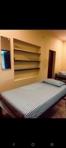 a large bed in a room with a wall at SMK homestay in Rāmeswaram