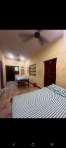 a bedroom with two beds and a bench in it at SMK homestay in Rāmeswaram