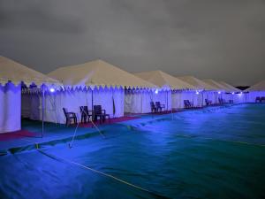 a row of tents with tables and chairs in them at White Thar Camp in Dhordo