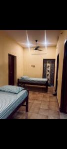 a room with two beds and a ceiling at SMK homestay in Rāmeswaram